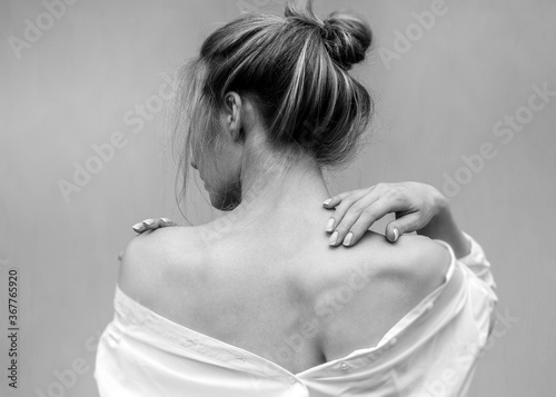 Woman's back. Hands on the shoulders and neck. Black and white photo
