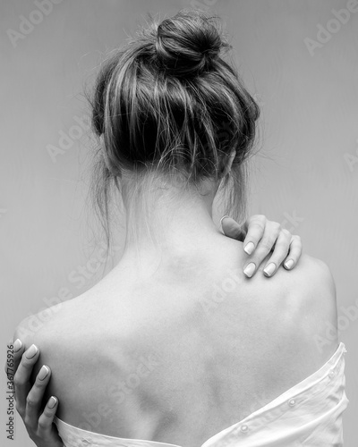 Woman's back. Hands on the shoulders and neck. Black and white photo