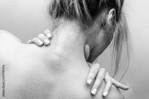 Woman's back. Hands on the shoulders and neck. Black and white photo