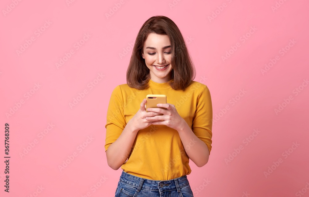 happy young woman good looking using mobile phone isolated over pink background. happy young woman good looking using mobile phone isolated over pink background.