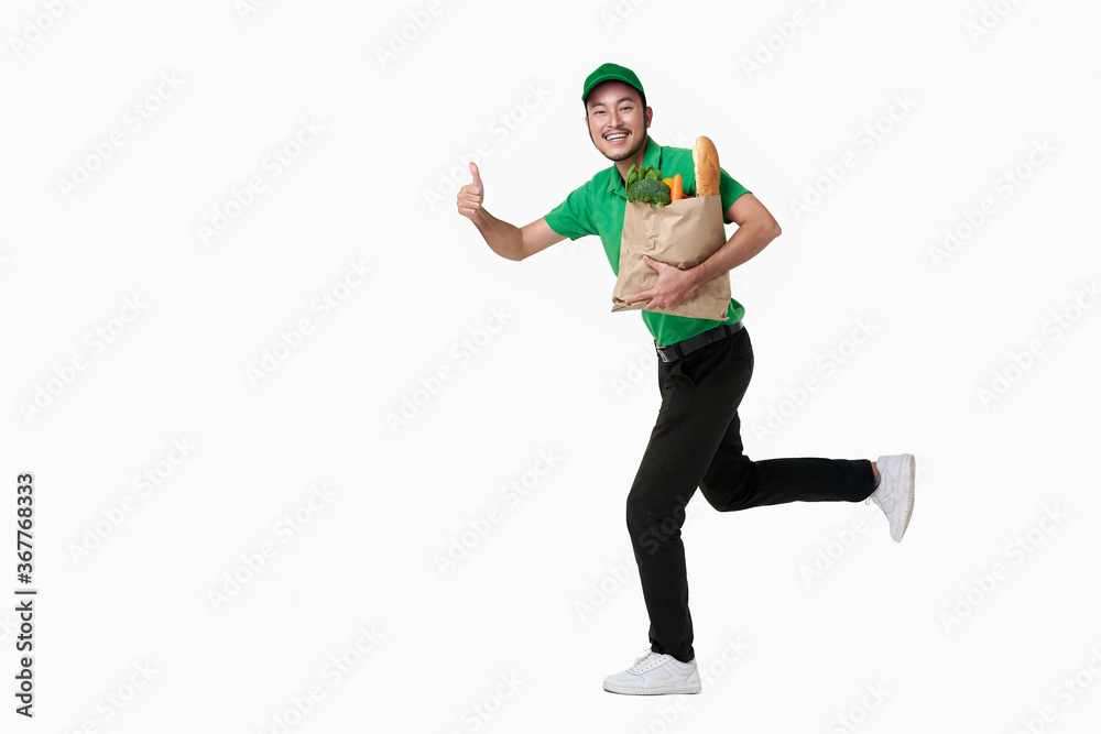 Asian delivery man wearing in green uniform holding fresh food paper bag isolated over white background.