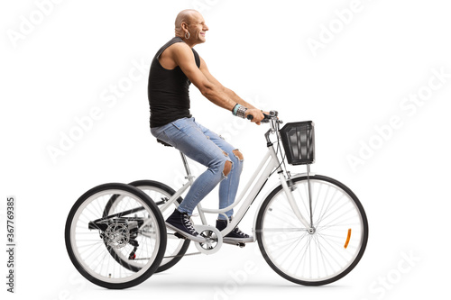 Profile shot of a middle aged man riding a tricycle