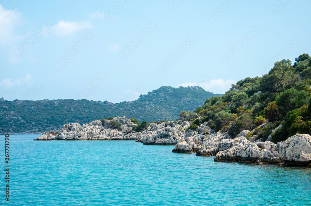 Seascape. View from the water to Islands in the Mediterranean sea. Wild unspoilt nature of Turkey. Stone cliffs and mountains covered with green bushes and trees. Summer landscape from pleasure boat