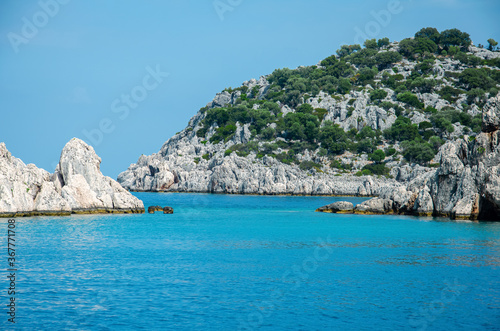 Seascape. View from the water to Islands in the Mediterranean sea. Wild unspoilt nature of Turkey. Stone cliffs and mountains covered with green bushes and trees. Summer landscape from pleasure boat