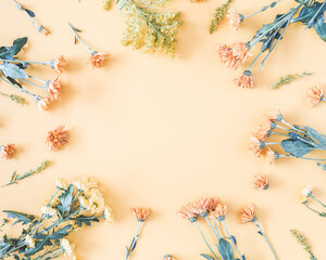 Autumn floral composition. Frame made of fresh flowers on pastel yellow background. Autumn, fall concept. Flat lay, top view, copy space