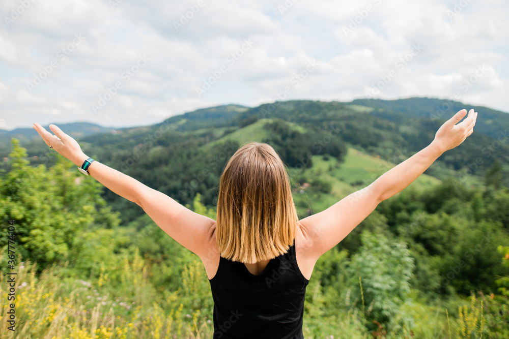 Young woman enjoying the view of a mountain range Young woman enjoying the view of a mountain range