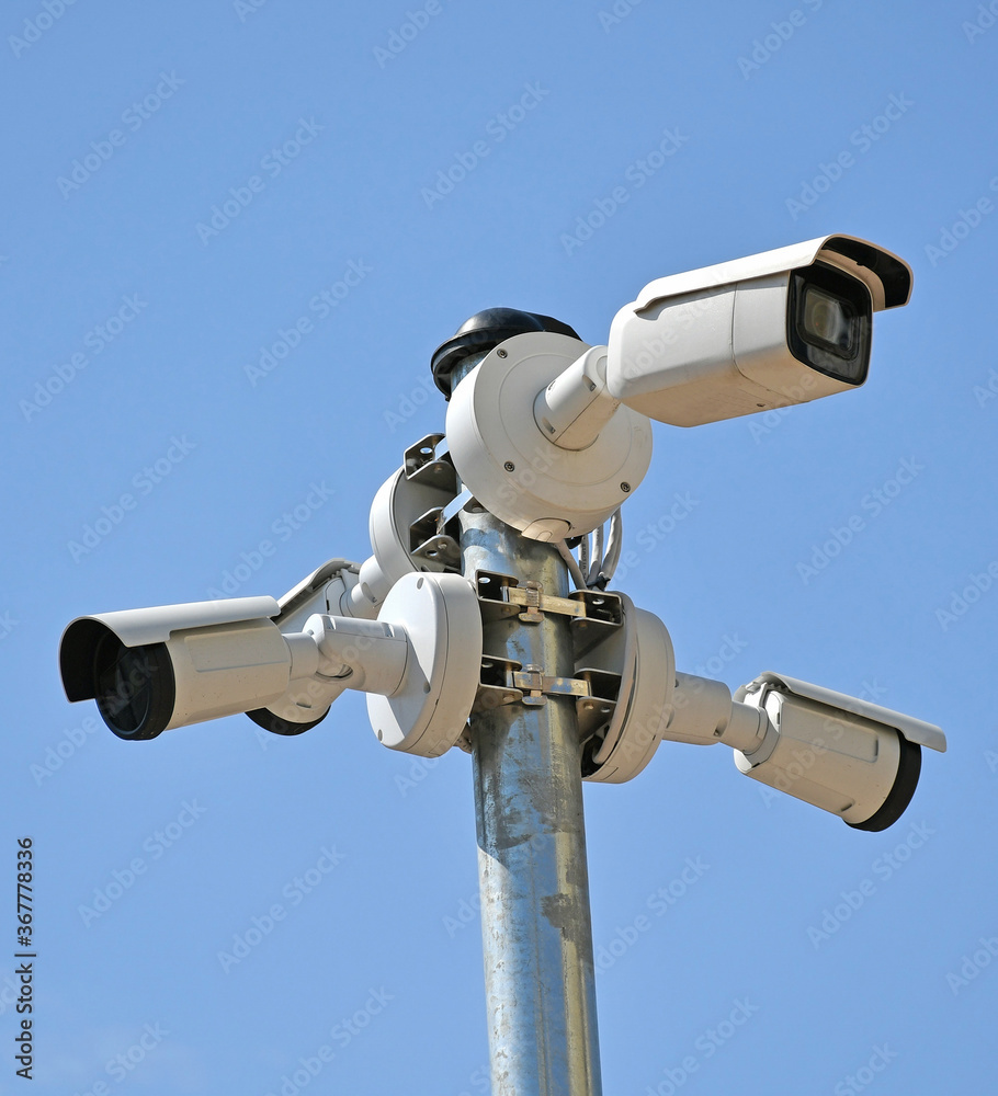 Security cameras on a metal pole against sky
