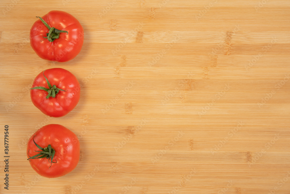 Fresh tomatoes on bamboo wooden background Fresh tomatoes on bamboo wooden background