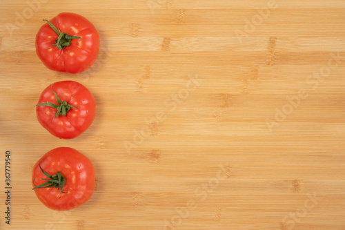 Fresh tomatoes on bamboo wooden background