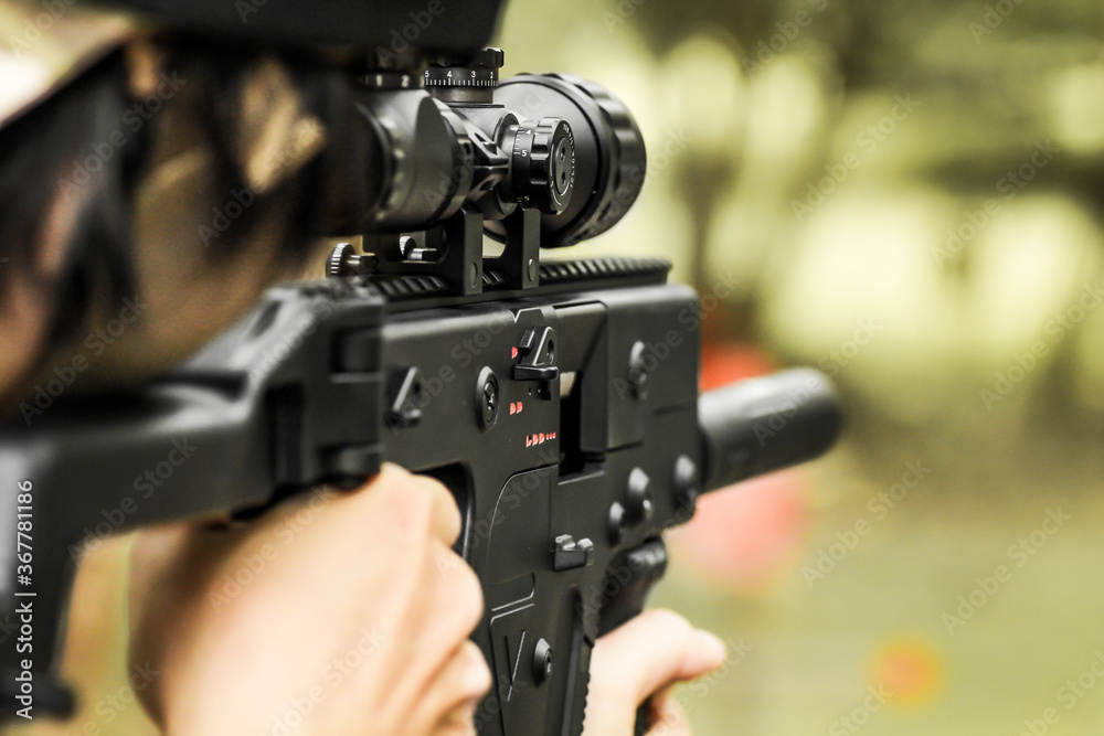 Military shooter with his precising assault rifle aiming and shooting target in the range Military shooter with his precising assault rifle aiming and shooting target in the range