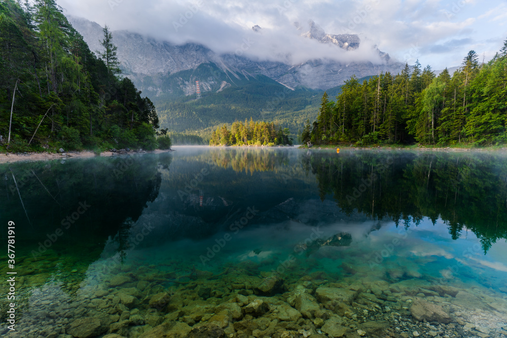 Beautiful and cloudy Summer sunrise at the Eibsee lake in German Alps, southwest of Garmisch-Partenkirchen below the Zugspitze in the Wetterstein Mountains in Bavaria