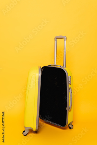 open empty travel bag on yellow background