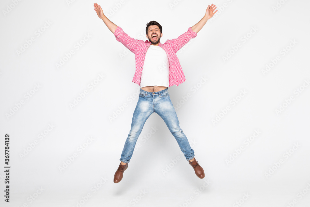 Excited young man jumping and smiling isolated on white background Excited young man jumping and smiling isolated on white background