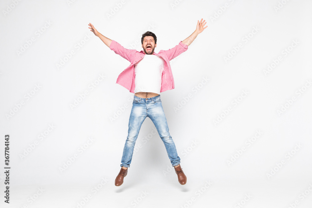 Excited young man jumping and smiling isolated on white background Excited young man jumping and smiling isolated on white background
