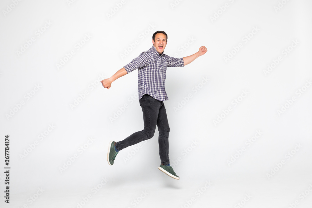 Cheerful young man jumping isolated over a white background
