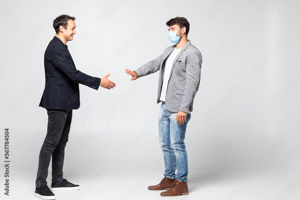 Two business man in suits refuse to greet each other in a meeting traditional handshake of covid situation in the world isolated on a white background. Covid concept Two business man in suits refuse to greet each other in a meeting traditional handshake of covid situation in the world isolated on a white background. Covid concept