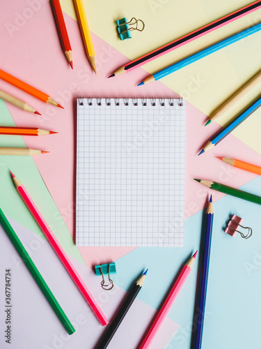 School notebook and pencils, on a multicolored background. Education concept. Back to school.