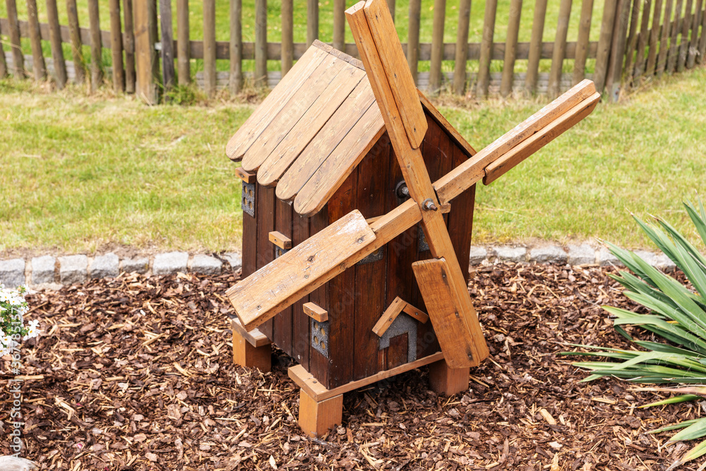 Small wooden decorative brown mill stands in the garden Small wooden decorative brown mill stands in the garden