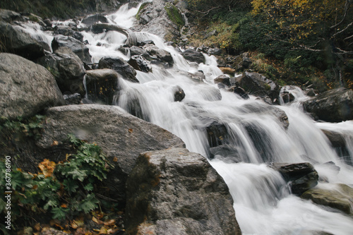 Stream of water of the mountains river, big stones, long exposure