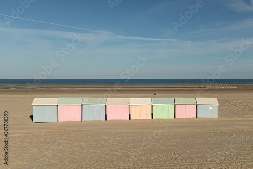 Multicolored beach huts lined up on the deserted beach of Berck in France