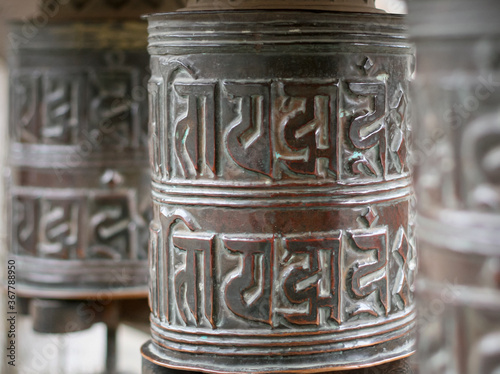 Three basic spinning prayer wheels in Nepal. Shallow Depth of Field. photo