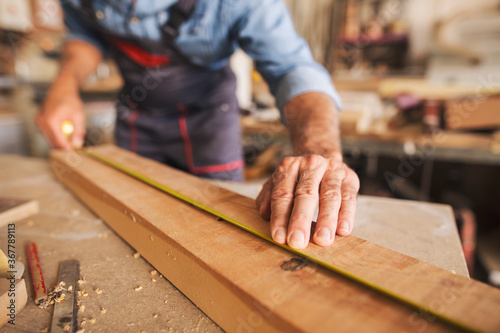 Canvas Print Close up of male hands measuring a piece of wood