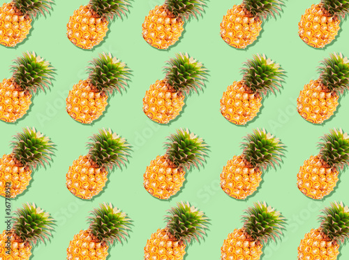 The texture colorful fruit pattern of pineapple fruit on green background, flat lay