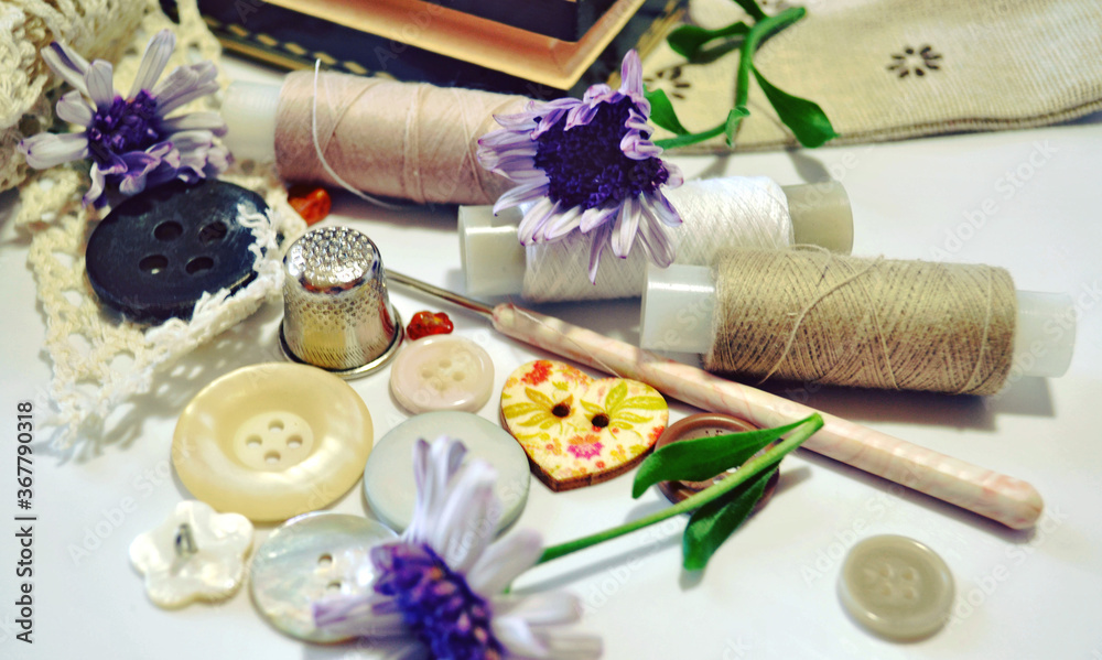 Sewing accessories in beige and ecru colours including vintage wooden box, cotton lace, sewing spools, buttons and flowers. Scrapbooking and DIY. Hobby and needle work background. Retro style Sewing accessories in beige and ecru colours including vintage wooden box, cotton lace, sewing spools, buttons and flowers. Scrapbooking and DIY. Hobby and needle work background. Retro style