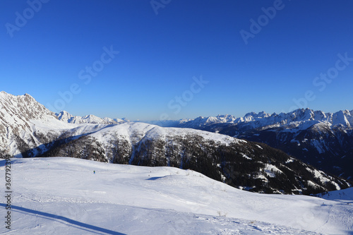 Obertilliach ski resort in west Austria in Tyrol. Panorama on Gailtal Alps with blue sky from top of Golzentipp. Scenery of ski slopes and snow mountains peaks © Fauren
