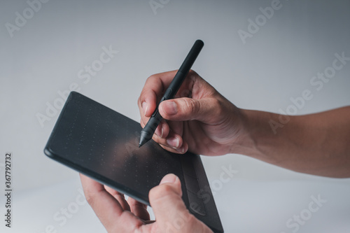 The man's hand showing the writing gesture on the tablet on the white background.