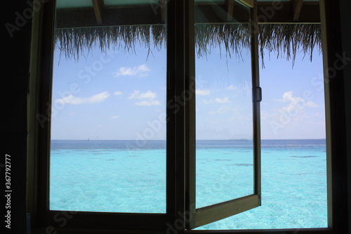 Iconic and beautiful view from an overwater bungalow on the turquoise blue water of the Indian ocean in Maldives island.