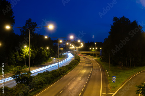 Light trails of passing by cars on nearly empty highway on cloudless night. © Marko Hannula