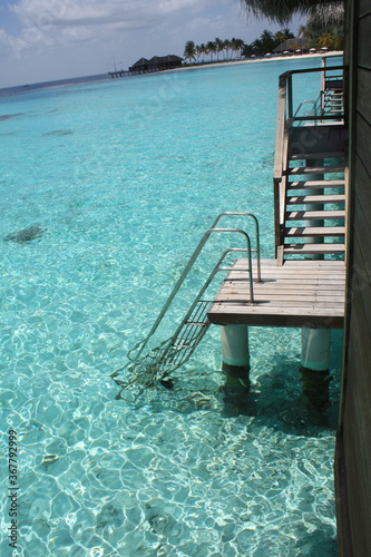 Beautiful isolated ladder of an overwater bungalow, down directly to the beautiful turquoise blue sea of a laggon in Indian ocean, Maldives.