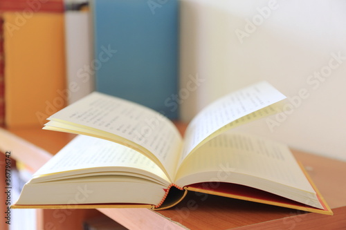 A close up of a book opening on a bookshelf in the library selective focus and shallow depth of field