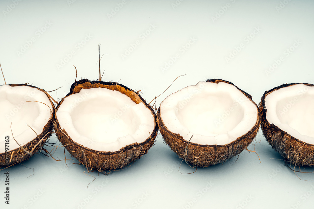 Parts of coconut on a colored background. Close up. Fresh ripe coconut broken into pieces. Parts of coconut on a colored background. Close up. Fresh ripe coconut broken into pieces.