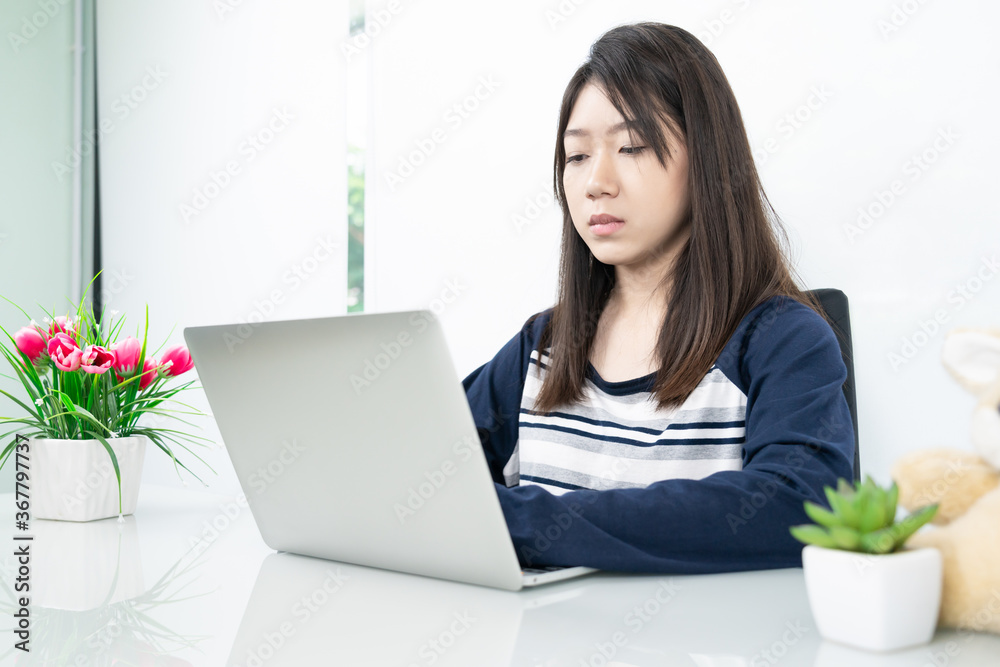 Young female student sitting in living room and learning online Young female student sitting in living room and learning online