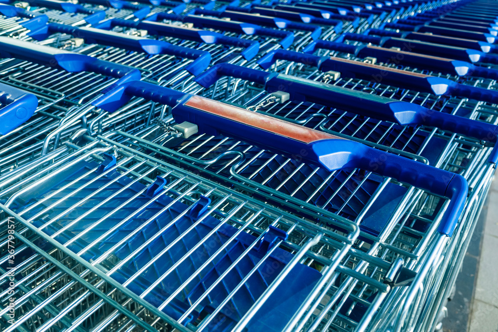Many shopping carts parked in front of a supermarket.