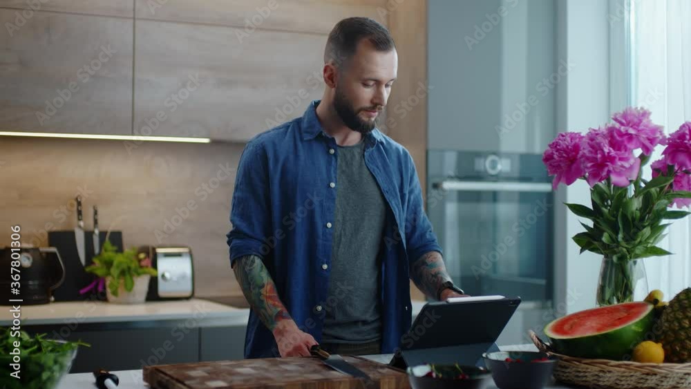 Young Man Searches the Recipe from a Tablet and Prepares All the Ingredients.