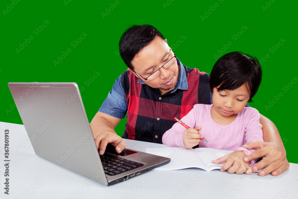 Father teaches his child to write during uses laptop Father teaches his child to write during uses laptop