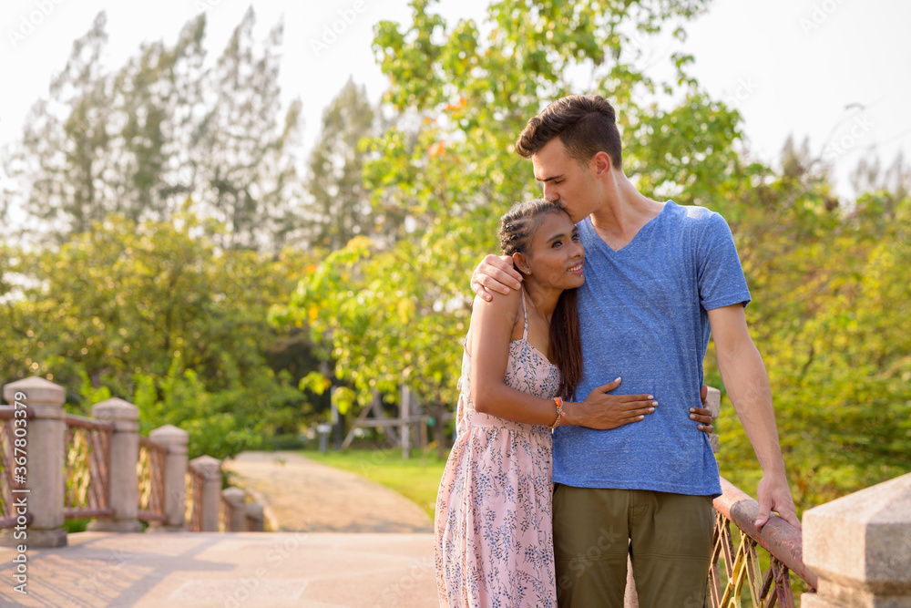 Portrait of young multi ethnic couple relaxing together at the park Portrait of young multi ethnic couple relaxing together at the park