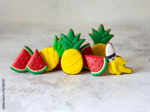 Gingerbread fruit on a neutral gray background with copy space. Watermelon, pineapple, banana with glasses. The concept of summer