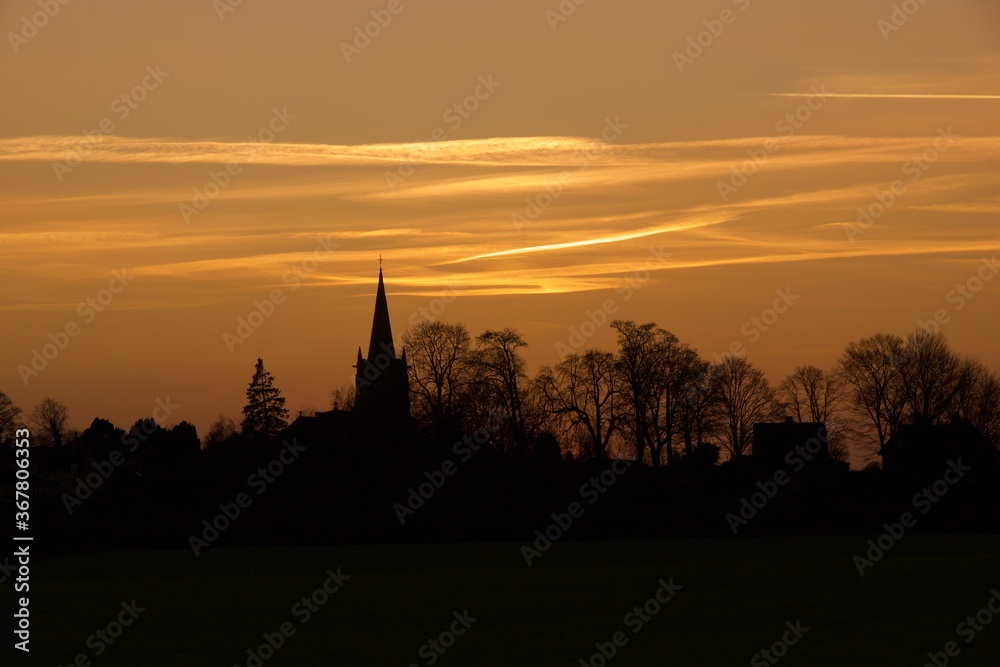 Sunset over an old English village church in January.