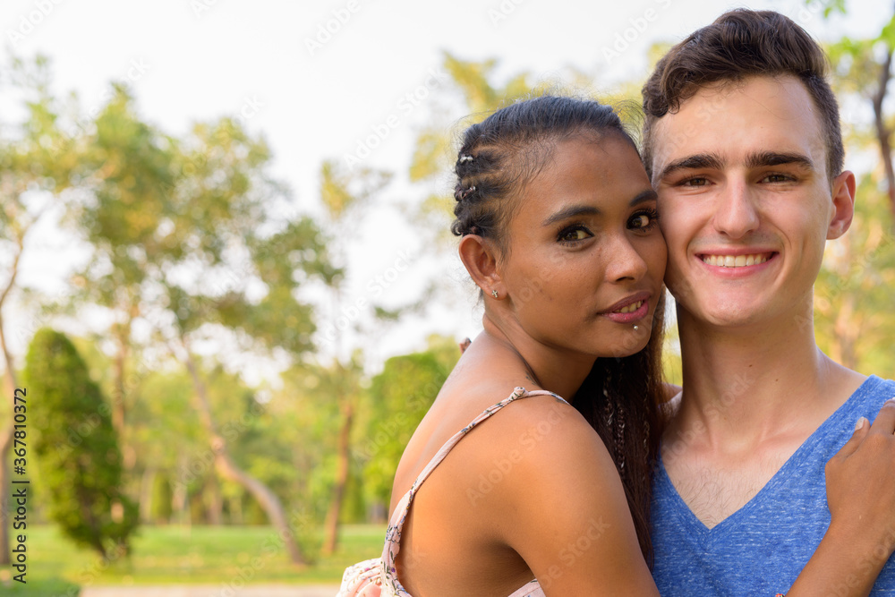 Portrait of young multi ethnic couple relaxing together at the park Portrait of young multi ethnic couple relaxing together at the park