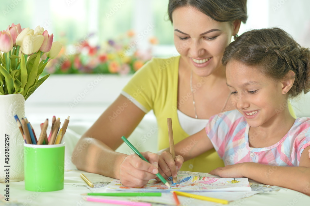 Cute girl with mother drawing at the table at home Cute girl with mother drawing at the table at home