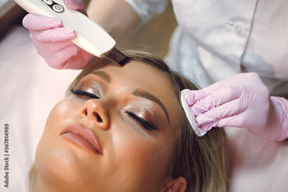 a woman does a procedure with a cosmetologist