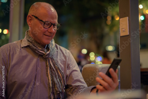Senior handsome Scandinavian tourist man exploring the city streets at night