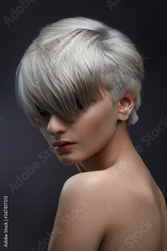 Print op canvas Beauty portrait of a cute ash blonde girl with a short stylish haircut on a gray background