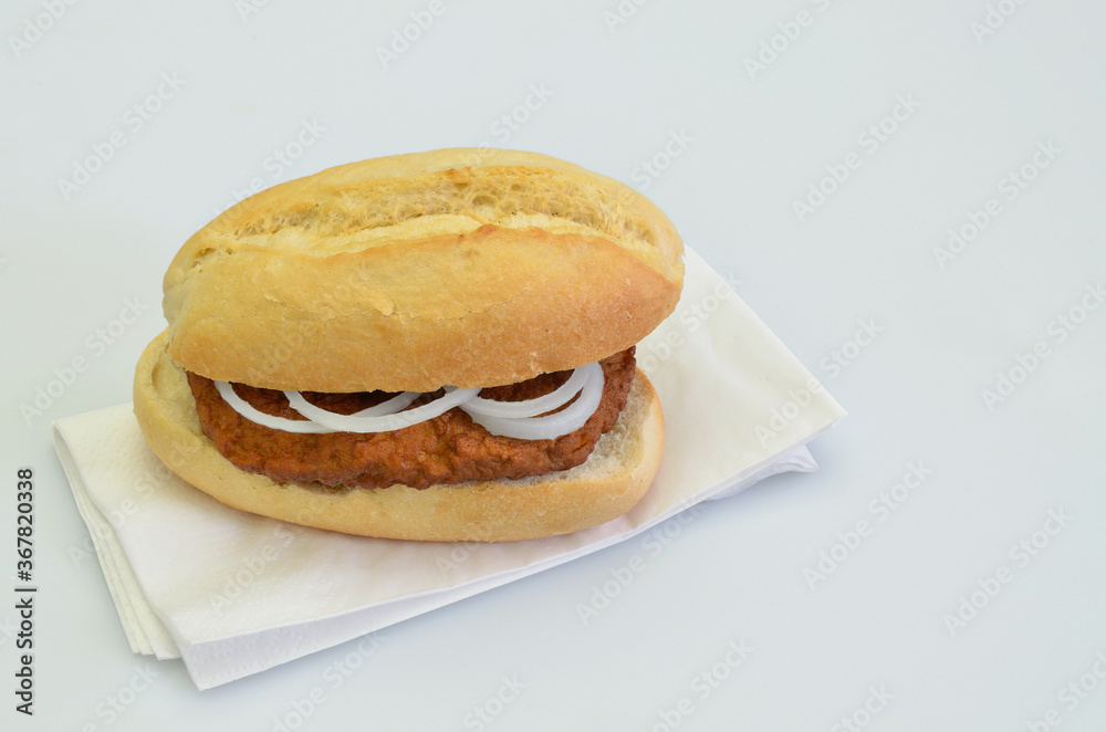 Hamburger with Onion rings in Bun on white Napkin, close up on white Background Hamburger with Onion rings in Bun on white Napkin, close up on white Background