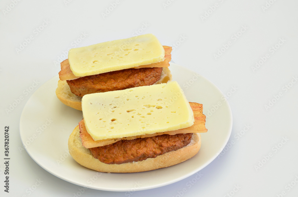 Two Sandwiches with Beef, Bacon and Cheese on white Plate