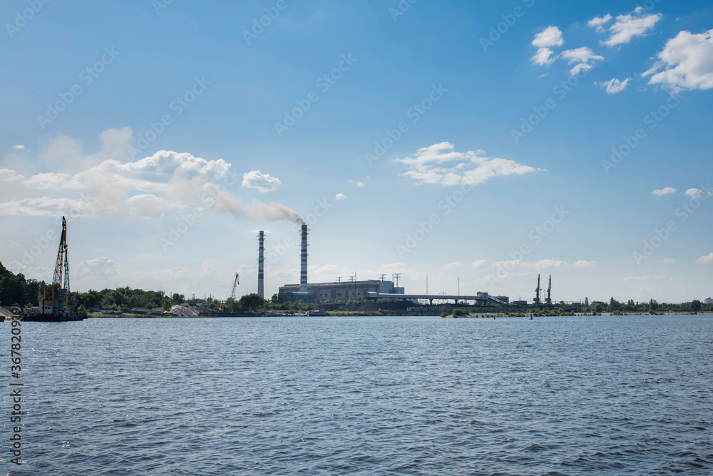 Coal mining. Coal mine. Natural heaps of industrial coal. View from the river.